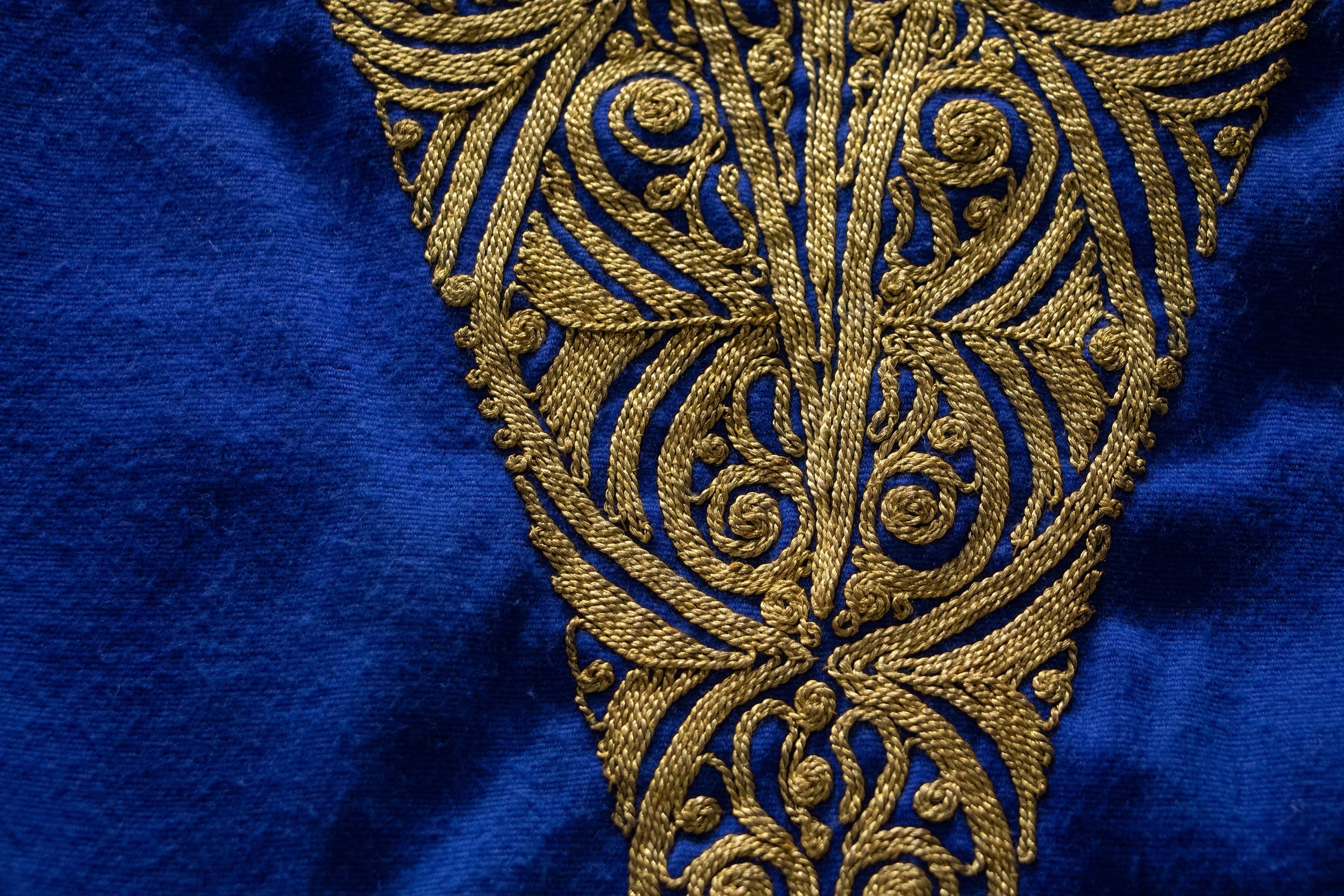 Bright blue fabric with intricate gold embroidered pattern